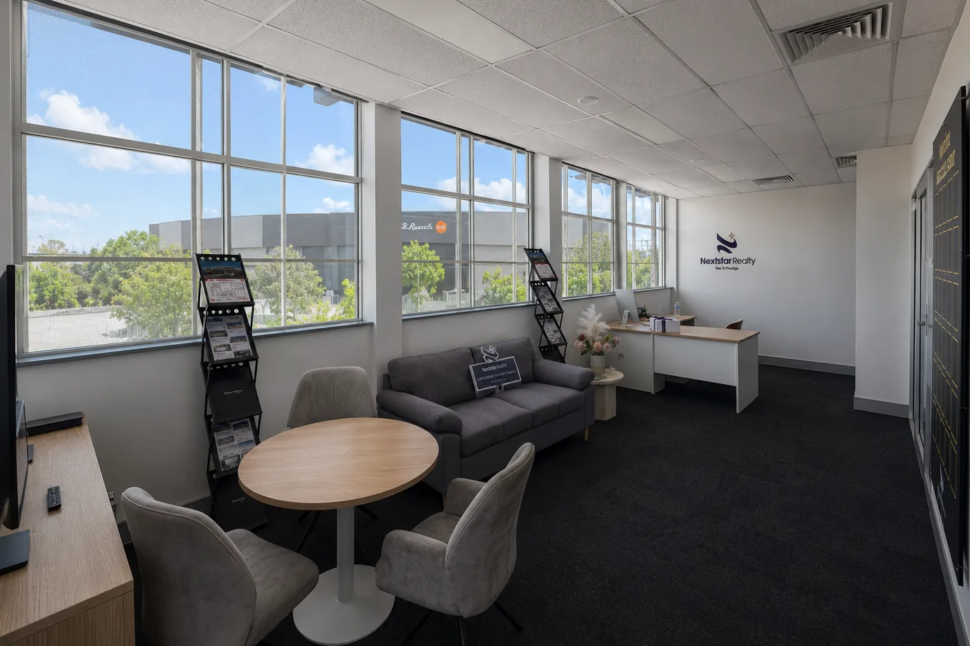 The Nextstar Realty office in Rocklea, Brisbane — meeting area, consultant desk and branded reception wall